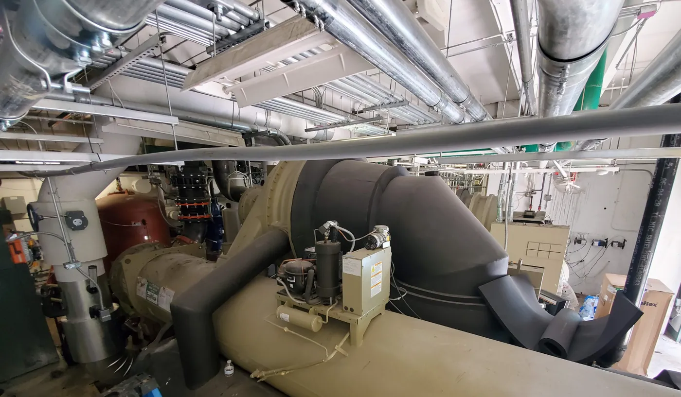 Centrifugal chiller and piping inside a campus chilled water plant